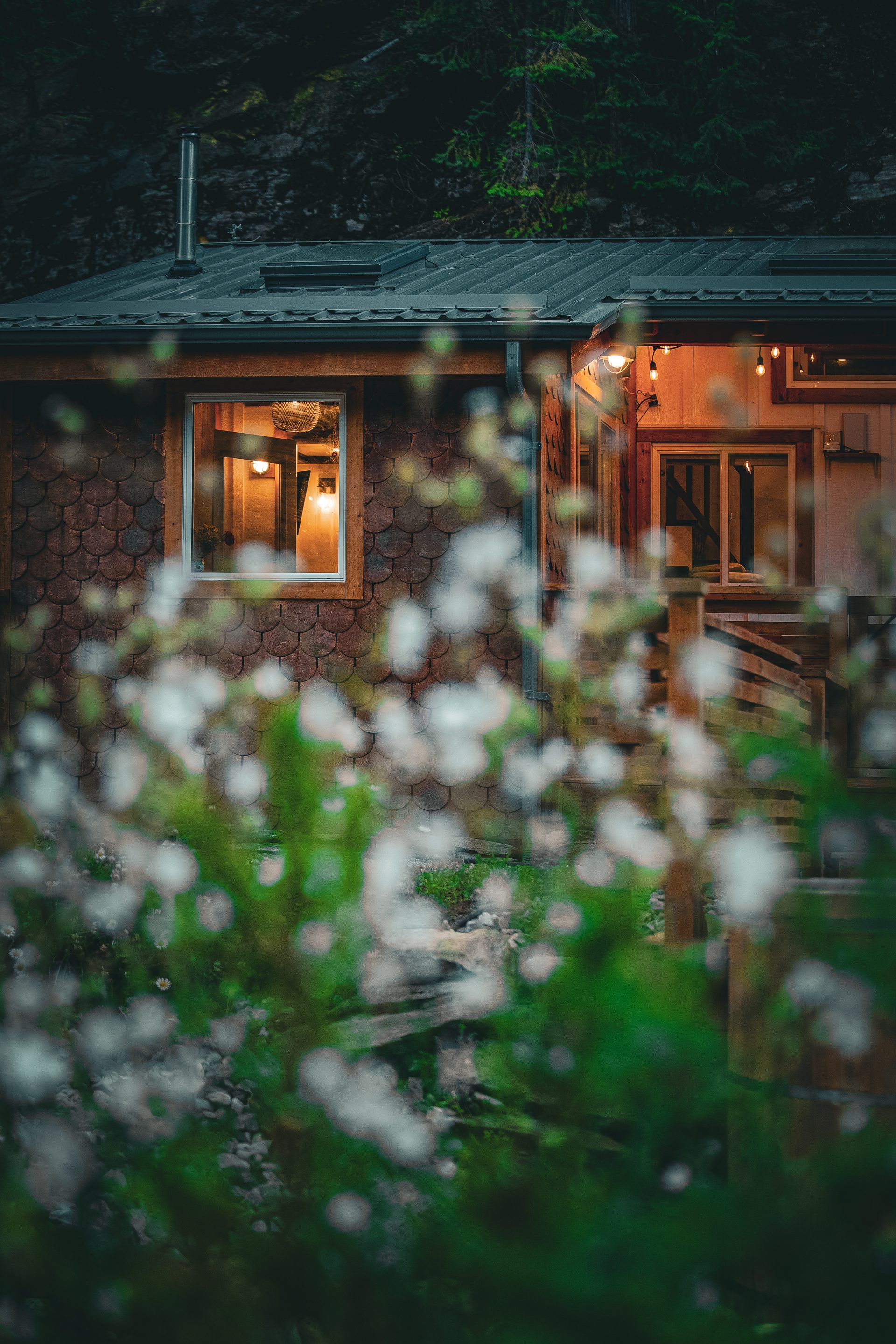 Covered deck with lounge seating, umbrella, and string lights