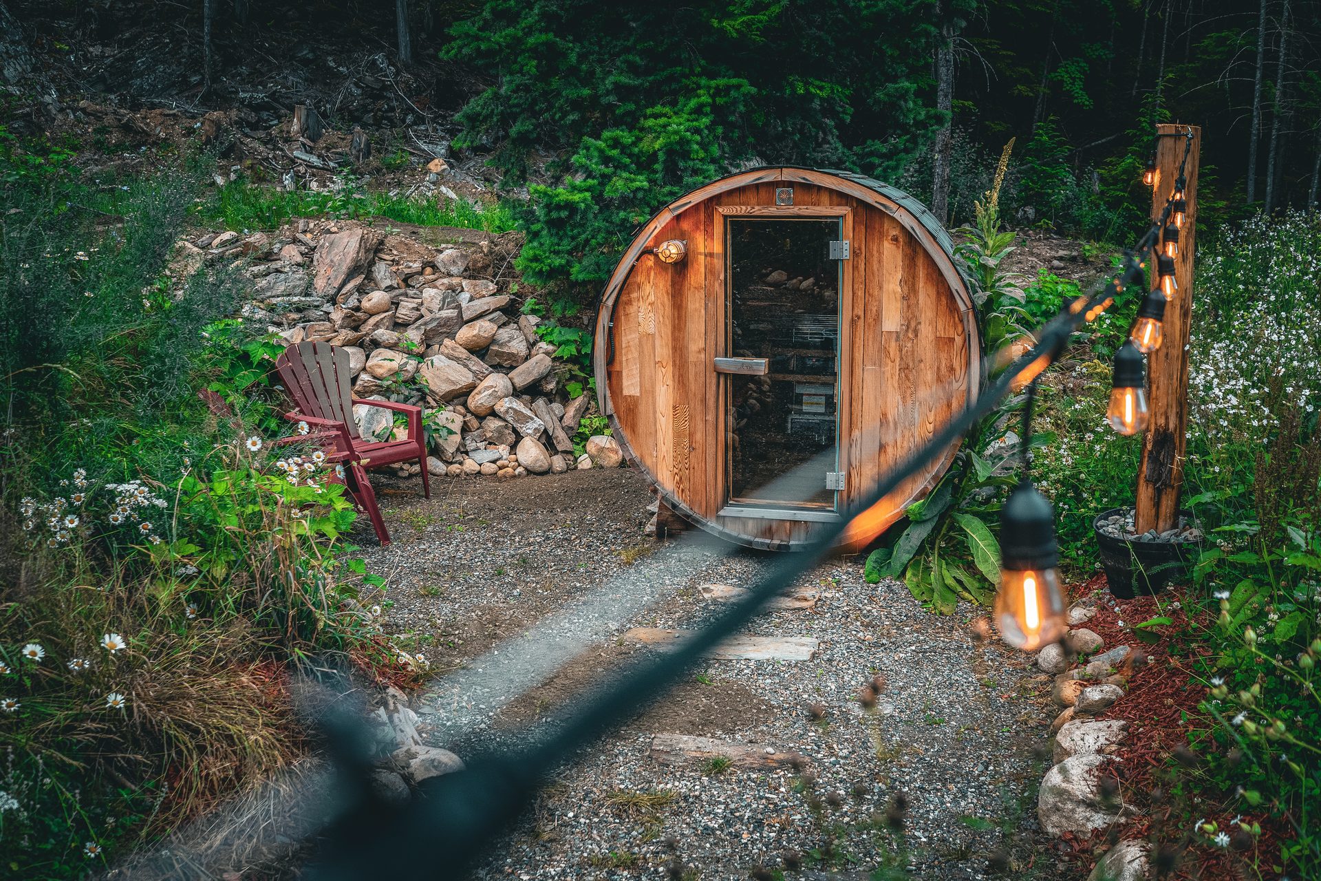 Front entrance of Enchanted Bluff House with fire pit and red Adirondack chairs